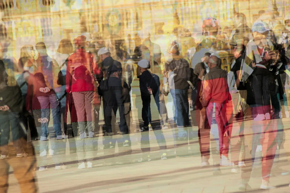 A crowd of people in a sunlit square, layered in a multiple exposure